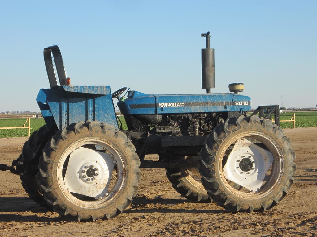 Blue tractor parked in a working agricultural field, the tools of real farming